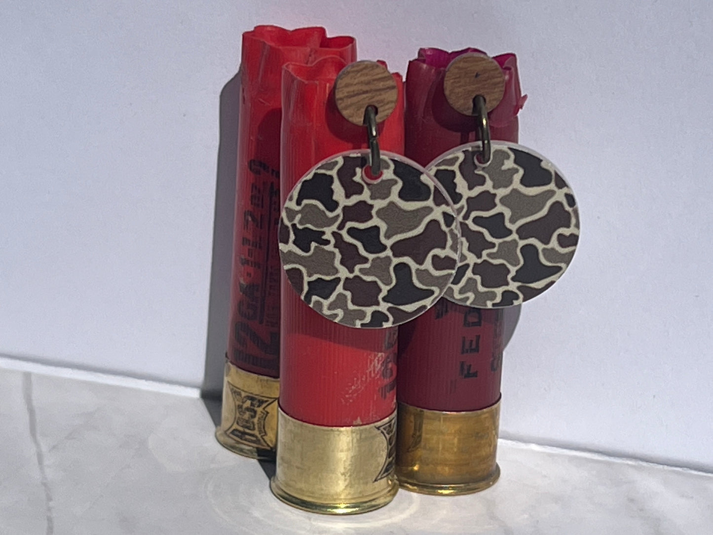 Three red shotgun shells with camouflage pattern on a white background